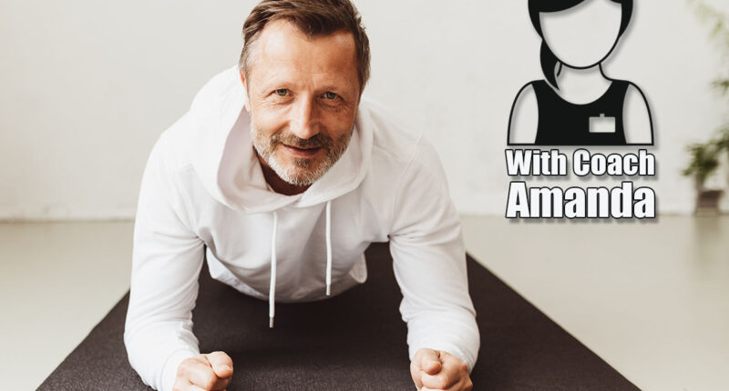 Portrait of a determined middle-aged man smiling while exercising plank on the forearms on a mat on the floor as workout routine at home during pandemic. If You Can Hold This Position for 90 Seconds After 45, Your Core Is Stronger Than 85% of Your Peers. Cover