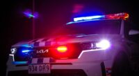 A QLD Kia Police car at night with its sirens on