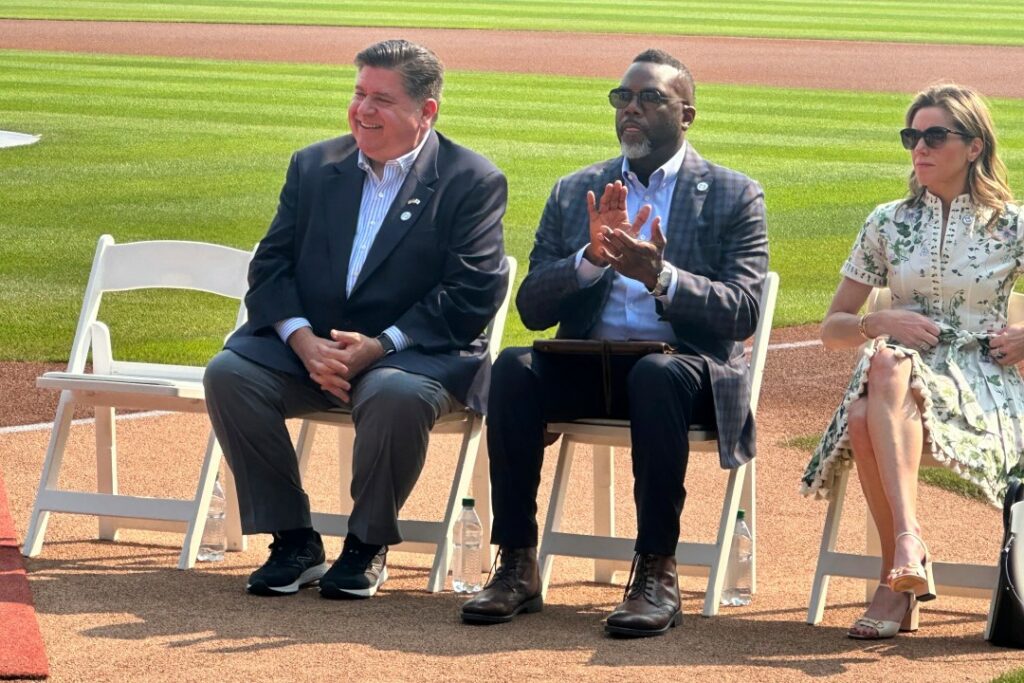 Illinois Gov. JB Pritzker, left, and Chicago mMyor Brandon Johnson listen during a baseball news conference, Friday, Aug. 1, 2025, in Chicago, announcing that the Chicago Cubs' Wrigley Field will host the 2027 All-Star Game. (AP Photo/Andrew Seligman)