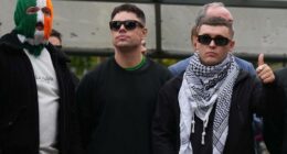 Liam Óg Ó hAnnaidh, aka Mo Chara, right, a member of the Irish language band Kneecap, celebrates as he leaves Woolwich Crown Court in London, Friday, Sept. 26, 2025, after Chief Magistrate, Senior District Judge Paul Goldspring, dismissed a terrorism offence relating to displaying a flag in support of Hezbollah during a performance with the band in November 2024, on a technical error.
