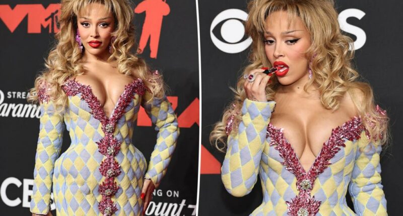 Doja Cat pairs sky-high platform heels with a $5,995 crystallized lipstick clutch on VMAs 2025 red carpet