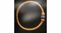 A gold bracelet with a blue bead on it