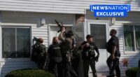 Police surround an apartment door