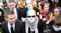 Hezbollah flag-waving Kneecap rapper has terror charge thrown out thanks to blundering CPS as his group's fans create circus at court