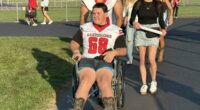 High school football player whose spine was fractured by rival in horrific attack returns to field in a wheelchair
