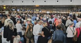 People stand in a line to check in after a cyber attack caused delays at Brussels International Airport in Zaventem, Belgium, Saturday, Sept. 20, 2025. (AP Photo/Harry Nakos)