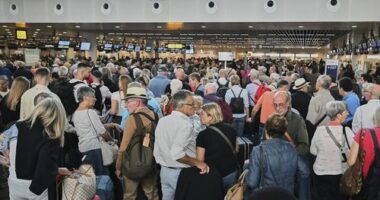People stand in a line to check in after a cyber attack caused delays at Brussels International Airport in Zaventem, Belgium, Saturday, Sept. 20, 2025. (AP Photo/Harry Nakos)