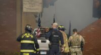 First responders stand behind the truck crashed into the Church of Latter-day Saints in Grand Blanc, Michigan.