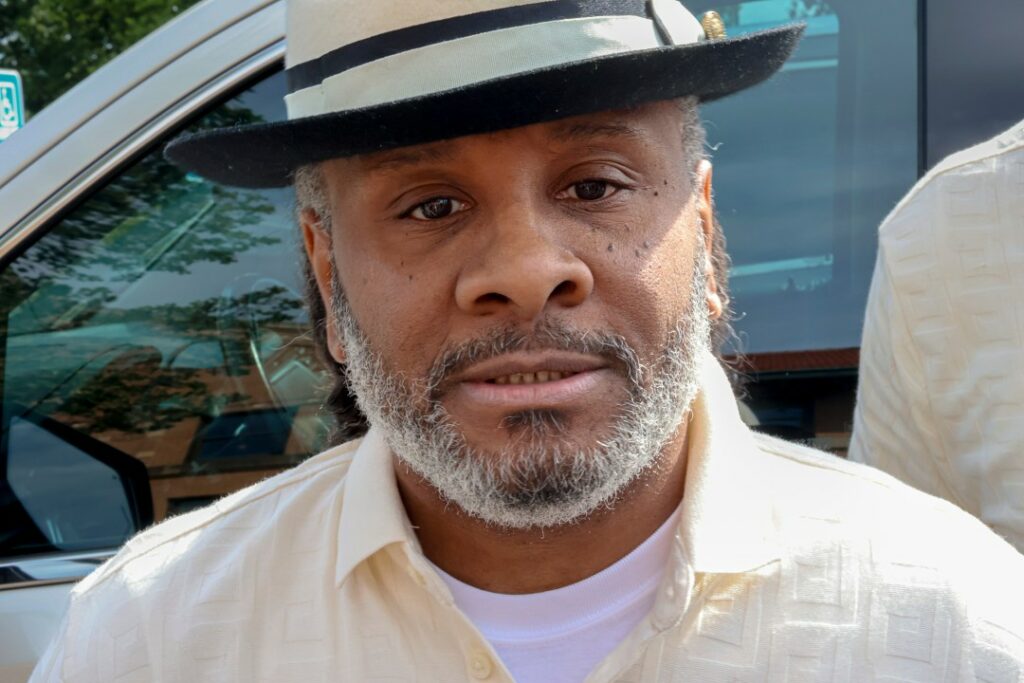 Bryan Hooper Sr. wearing dress shirt and hat