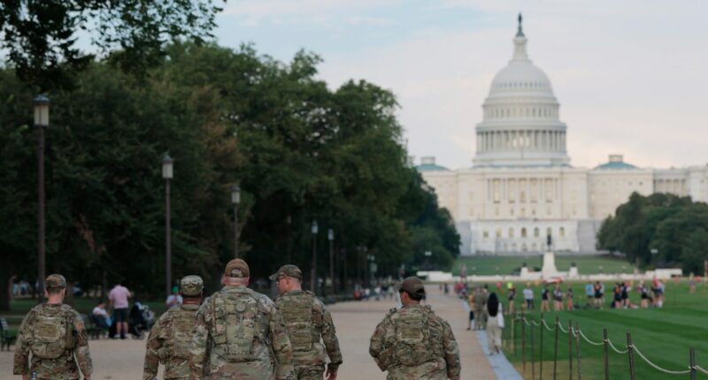 members of the National Guard walk on the National Mall