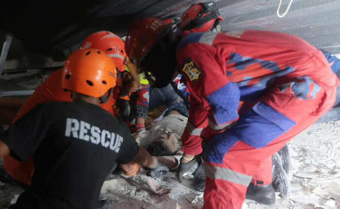 Rescuers run oxygen to survivors in Indonesia school building collapse that buried dozens