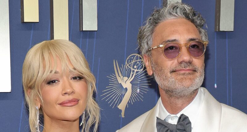 Rita Ora's glossy look turns heads as she third wheels husband Taika Waititi - while he cosies up to a VERY famous star on the Emmys red carpet