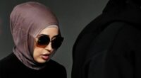 New South Wales health former nurse Sarah Abu Lebdeh arrives surrounded by supporters at the Downing Centre local court in Sydney.