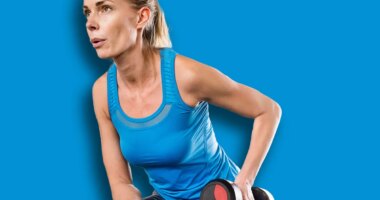 Woman exercising with dumbbells in gym. Strength exercise. Routine workout for physical and mental health.