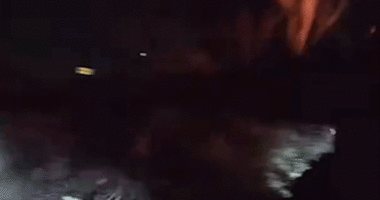 gif of officers bashing car window with baton as fire engulfs vehicle