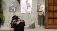 FILE - Mourners embrace during a memorial for Los Angeles Angels pitcher Tyler Skaggs at the St. Monica Catholic Church, July 22, 2019, in Los Angeles. (AP Photo/Marcio Jose Sanchez, File)