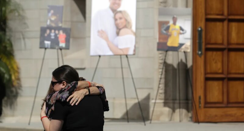 FILE - Mourners embrace during a memorial for Los Angeles Angels pitcher Tyler Skaggs at the St. Monica Catholic Church, July 22, 2019, in Los Angeles. (AP Photo/Marcio Jose Sanchez, File)