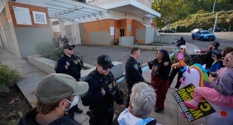 Law enforcement officers talk with protesters outside a United States Immigration and Customs Enforcement (ICE) facility in Portland, Ore., Monday, Oct. 20, 2025. (AP Photo/Jenny Kane)