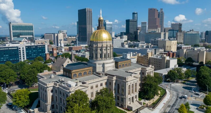 FILE - The gold dome of the Georgia Capitol gleams in the sun, Aug. 27, 2022, in front of the skyline of downtown Atlanta. (AP Photo/Steve Helber, File)