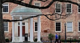 FILE - People walk through University of North Carolina campus March 18, 2020, in Chapel Hill, N.C. (AP Photo/Gerry Broome, File)