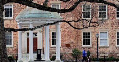 FILE - People walk through University of North Carolina campus March 18, 2020, in Chapel Hill, N.C. (AP Photo/Gerry Broome, File)