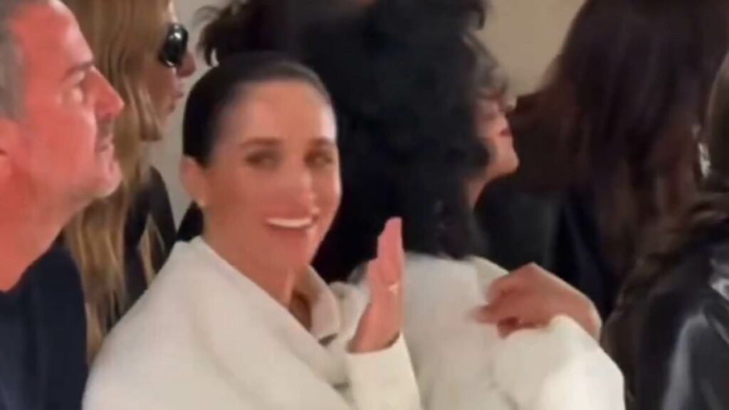 Meghan giggles as model 'stumbles on the catwalk'