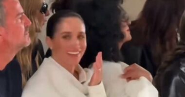 Meghan giggles as model 'stumbles on the catwalk'