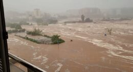 Moment roads become rivers as floodwaters sweep away cars in Spain - trapping the masses as ALL trains to and from country's biggest cities are cancelled