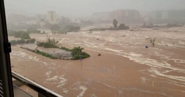 Moment roads become rivers as floodwaters sweep away cars in Spain - trapping the masses as ALL trains to and from country's biggest cities are cancelled