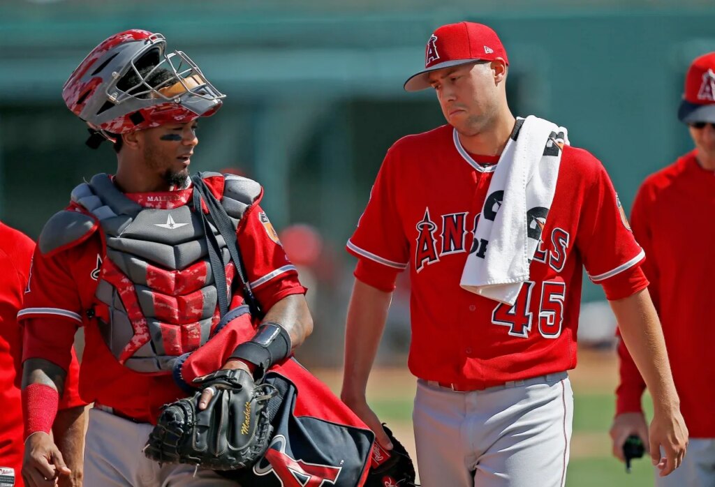 FILE - Los Angeles Angels starting pitcher Tyler Skaggs (45) talks with catcher Martin Maldonado, left, after warming up in the bullpen prior to a spring training baseball game against the Chicago White Sox, March 4, 2017, in Glendale, Ariz. (AP Photo/Ross D. Franklin, File)