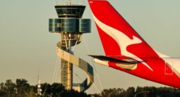 A Qantas Airbus A330-202 plane, registration VH-EBM, passing the air traffic control tower as she taxis at Sydney Kingsford-Smith Airport in preparation for departure as flight QF43 to Denpasar.