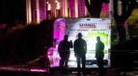 Police officers examine a U-Haul truck involved in a shooting at the entrance to Coast Guard Base Alameda, according to an officer at the scene, on Friday, Oct. 24, 2025, in Oakland, Calif. (AP Photo/Noah Berger)