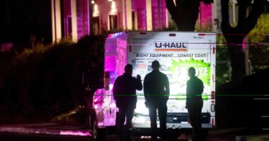 Police officers examine a U-Haul truck involved in a shooting at the entrance to Coast Guard Base Alameda, according to an officer at the scene, on Friday, Oct. 24, 2025, in Oakland, Calif. (AP Photo/Noah Berger)