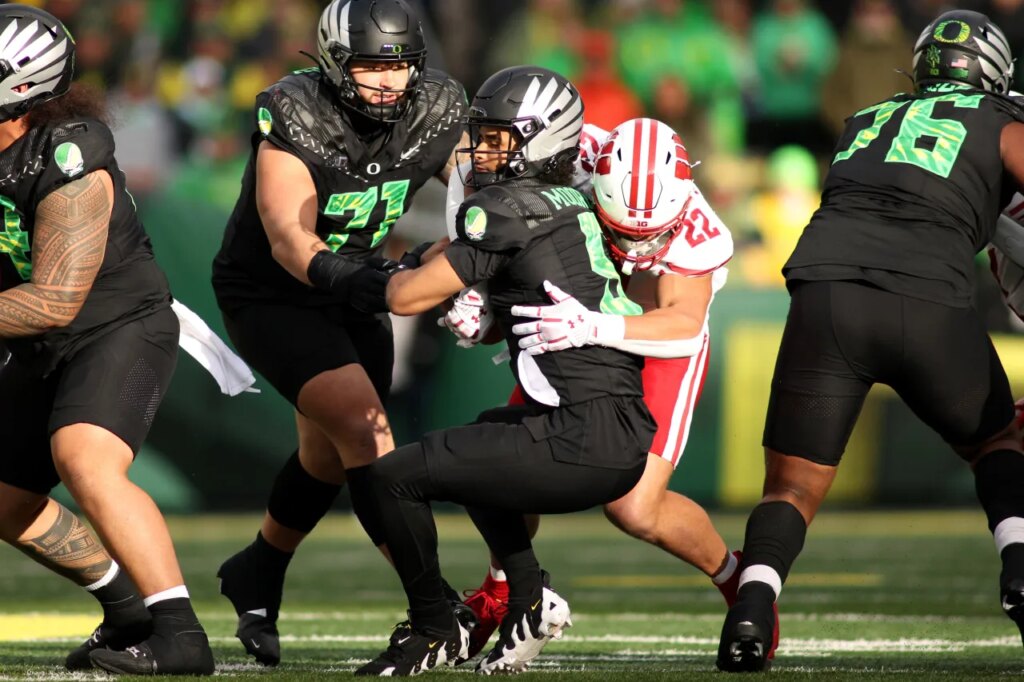 Oregon quarterback Dante Moore (5) is sacked by Wisconsin linebacker Mason Reiger (22) during the first half of an NCAA college football game Saturday, Oct. 25, 2025, in Eugene, Ore. (AP Photo/Lydia Ely)