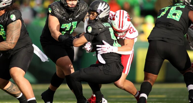 Oregon quarterback Dante Moore (5) is sacked by Wisconsin linebacker Mason Reiger (22) during the first half of an NCAA college football game Saturday, Oct. 25, 2025, in Eugene, Ore. (AP Photo/Lydia Ely)