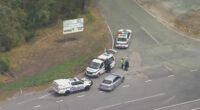 An aerial shot of multiple police cars on a road in QLD.