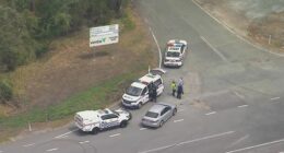 An aerial shot of multiple police cars on a road in QLD.