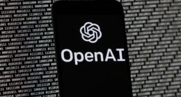 The OpenAI logo appears on a mobile phone in front of a computer screen with random binary data, March 9, 2023, in Boston. (AP Photo/Michael Dwyer, File)