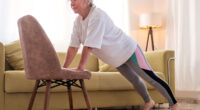 Senior caucasian woman doing yoga at home on chair