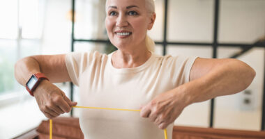 Cheerful blonde lady doing an upper-body exercise