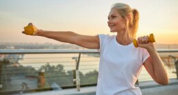 woman outdoors doing arm exercises with dumbbells for lean arms