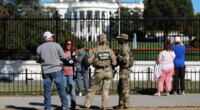 FILE - People talk with National Guard soldiers on the Ellipse, with the White House in the background, Oct. 17, 2025, in Washington. (AP Photo/Rahmat Gul, File)