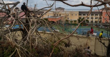 Locals gather next to a resort in Montego Bay, Jamaica, Friday, Oct. 31, 2025, in the aftermath of Hurricane Melissa. (AP Photo/Matias Delacroix)