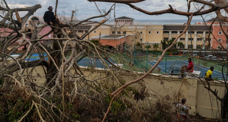 Locals gather next to a resort in Montego Bay, Jamaica, Friday, Oct. 31, 2025, in the aftermath of Hurricane Melissa. (AP Photo/Matias Delacroix)