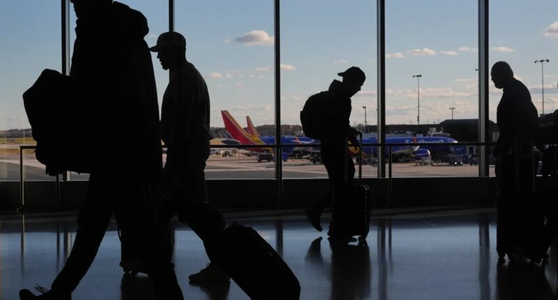 Southwest Airlines planes sit at gates as travelers walk through Baltimore/Washington International Thurgood Marshall Airport in Baltimore, Monday, Nov. 10, 2025. (AP Photo/Stephanie Scarbrough)