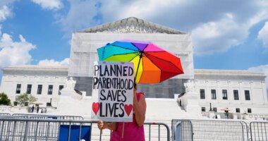 FILE - A protester stands outside of the Supreme Court, June 26, 2025, in Washington. (AP Photo/Mariam Zuhaib, File)