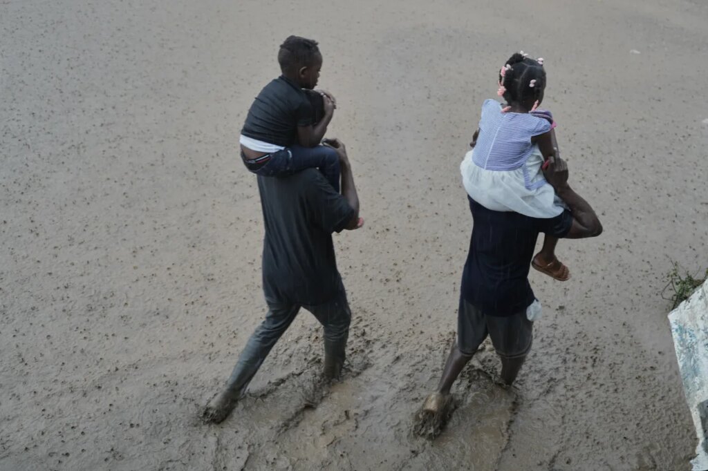 FILE - Residents wade through a flooded street in the aftermath of Hurricane Melissa in Petit-Goave, Haiti, Oct. 30, 2025. (AP Photo/Odelyn Joseph, File)