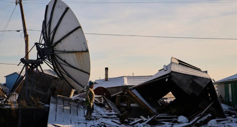 Harry Friend walks among debris caused by the remnants of Typhoon Halong hitting the village and region earlier in the month, Monday, Oct. 27, 2025, in Kwigillingok, Alaska. (AP Photo/Lindsey Wasson)