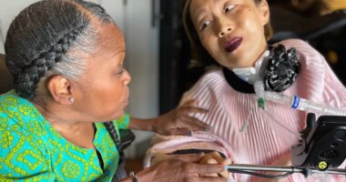 This March 2024 photo provided by Sandy Ho shows Yomi Young, left, speaking with Alice Wong at Wong