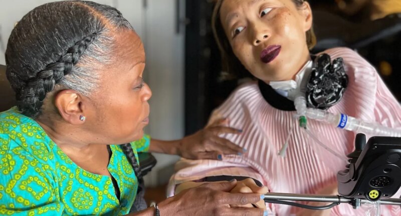 This March 2024 photo provided by Sandy Ho shows Yomi Young, left, speaking with Alice Wong at Wong